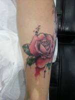Tatuaje de una rosa con manchas de pintura