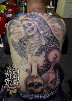 Tatuaje de un esqueleto rezando a tamaño gigante