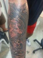 Tatuaje en el antebrazo de una carpa transformándose en dragón 