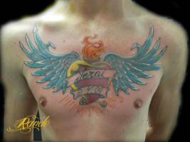 Tatuaje en el pecho de un sagrado corazón con alas y un nombre