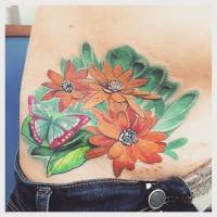 Tatuaje de unas flores con una mariposa en la cadera