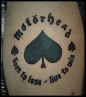 Tatuaje de un As de picas con el logo de Motörhead, y una frase