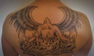 Tatuaje de un ángel entre llamas y la frase Carpe Diem