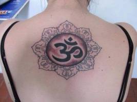 Tattoo de un mandala con el Om dentro, en la espalda de una chica