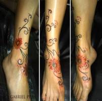 Tattoo de una enredadaera con flor en el pie