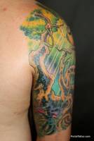 Tattoo de un árbol con un loro en la parte de atrás del brazo