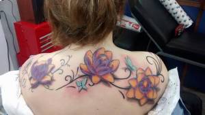 Color tattoo de flores en la espalda de una chica