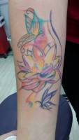 Tattoo de una mariposa y una flor, con manchas de pintura
