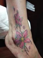 Tattoo de una enredadera con flor en el pie