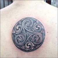 Tatuaje de un trisquel celta en la columna de un hombre