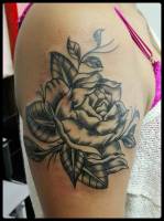 Tattoo de una rosa en blanco y negro en el brazo de una mujer