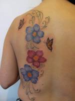 Tattoo de flores y mariposas en la espalda