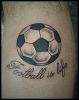 Tattoo de una pelota de fútbol y una frase que dice Football is life