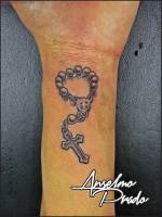 Tatuaje de una pulsera con una cruz