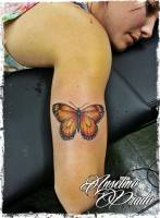 Tattoo de una mariposa en el brazo de una chica