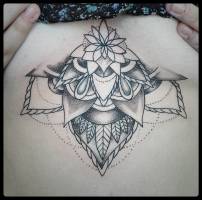 Tattoo de medio mandala con flor, en el pecho de una chica